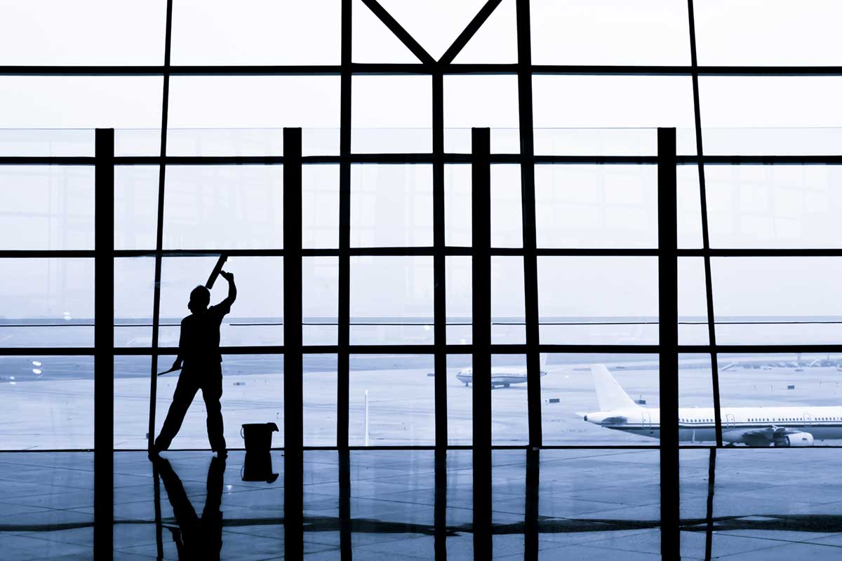 Employee cleaning the windows at an airport